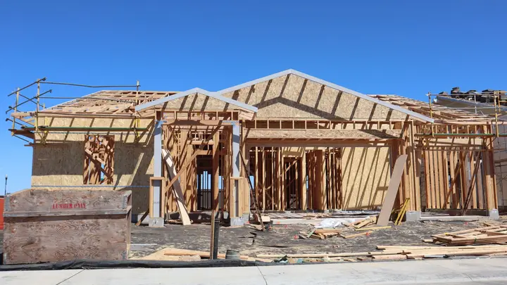 The wood frame of a new home under construction on a sunny day