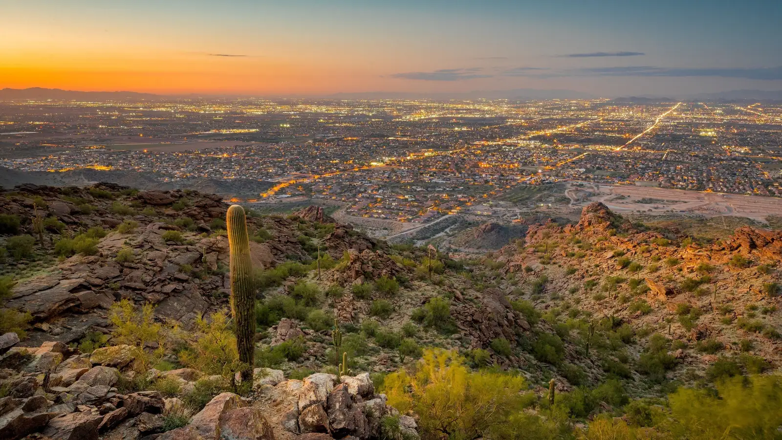 Atardecer sobre Laveen y el valle de Phoenix visto desde South Mountain, con las luces de la ciudad encendiéndose